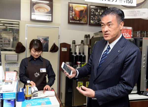 在日本东京的一家罗森便利店，罗森集团董事长兼首席执行官玉塚元一（右）体验使用支付宝结账。