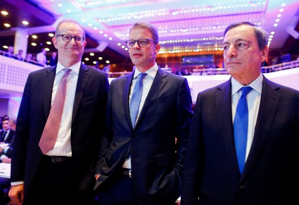 资料图片：2018年11月16日，德国商业银行CEO马丁·齐尔克（左）、德意志银行CEO克里斯蒂安·泽温（中）以及欧洲央行行长马里奥·德拉吉（右）共同出席第二十八届法兰克福欧洲银行业大会。（路透社）