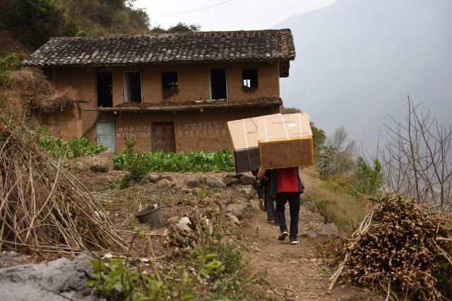 穿过大桥后,还要背一段路才能送到老乡家里