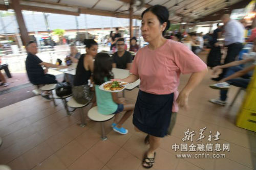 3月28日，一名小贩在新加坡纽顿熟食中心递送食物。