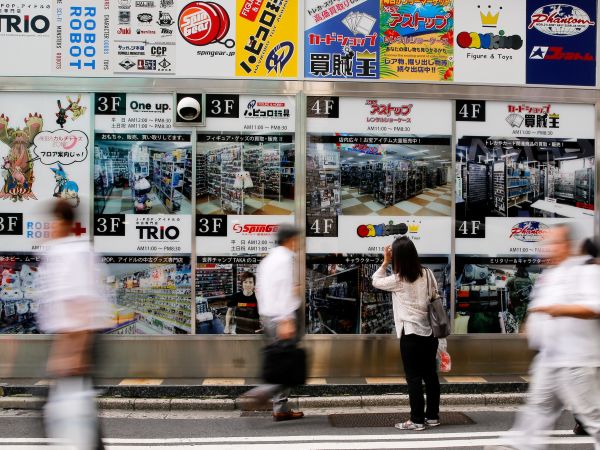 资料图：在日本东京，一名女子观看一家商场的告示牌。 （新华社）