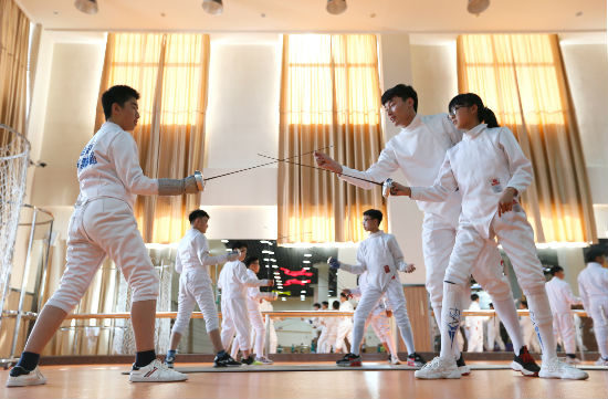 6月13日，山东青岛通济实验学校击剑社团的学生在老师的指导下进行训练。