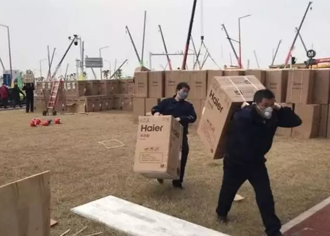 图为海尔的工人师傅将热水器一台台扛向1.5公里以外的病房