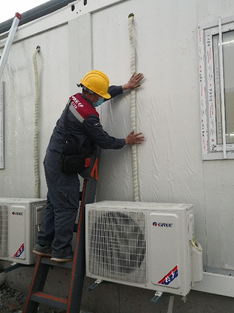 张林正在雷神山医院施工现场安装空调外机排水管