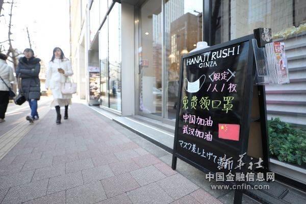 2月11日，在日本东京，银座的一个商铺门前的招牌上写着免费赠送口罩和为中国武汉加油鼓劲的内容。