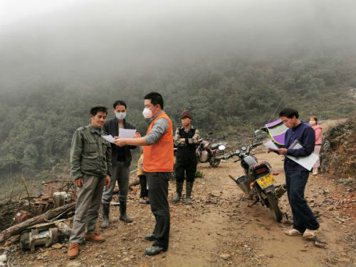 大化瑶族自治县雅龙乡红日村驻村第一书记覃云州（左三）开展防疫宣传（2月13日摄）。