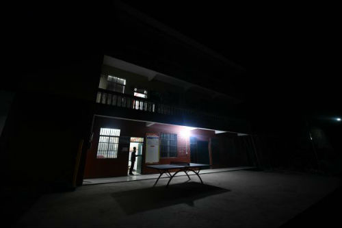 大化瑶族自治县板升乡八好村驻村第一书记韦德王走出村委办公室，准备夜访贫困户（1月6日摄）。