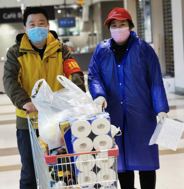 图1：李捷（左）帮助社区居民购买生活用品（图片来源：中国农业银行）