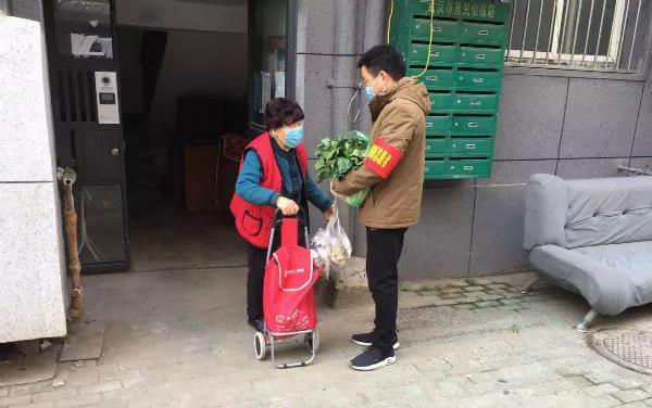 图4：李捷（右）为社区独居老人送蔬菜（图片来源：中国农业银行）