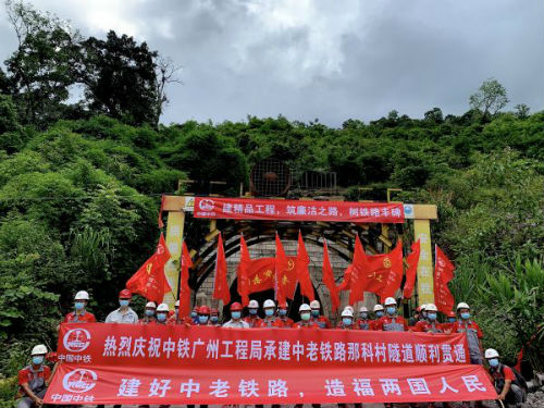 6月21日，中国中铁广州局员工在老挝乌多姆赛省已贯通的中老铁路那科村隧道前合影。