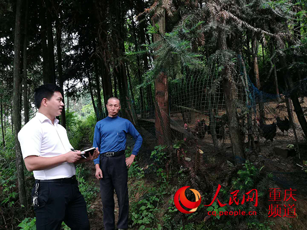 费明江（左一）向村民了解家庭养殖情况。邮储银行重庆分行 供图