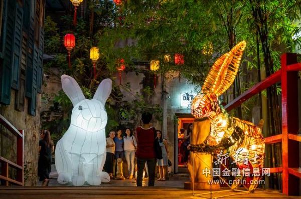 9月29日，在马来西亚吉隆坡鬼仔巷，人们与玉兔灯饰艺术品合影。新华社记者 朱炜 摄