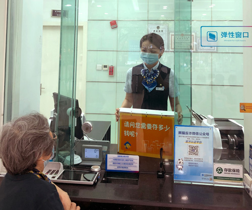 建行成都金河支行，柜面员工使用“关爱服务卡”服务老年客户